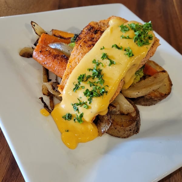 Rendezvous Bar & Grill's salmon with yellow sauce and parsley, served with roasted potatoes and carrots.
